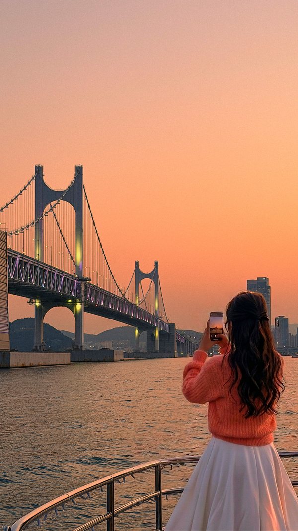 面向廣安大橋拍日落照片的遊客