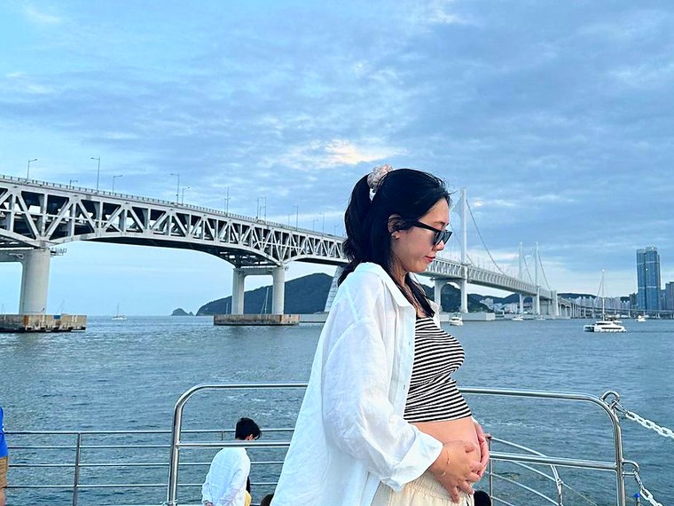以廣安大橋為背景站在甲板上的遊客