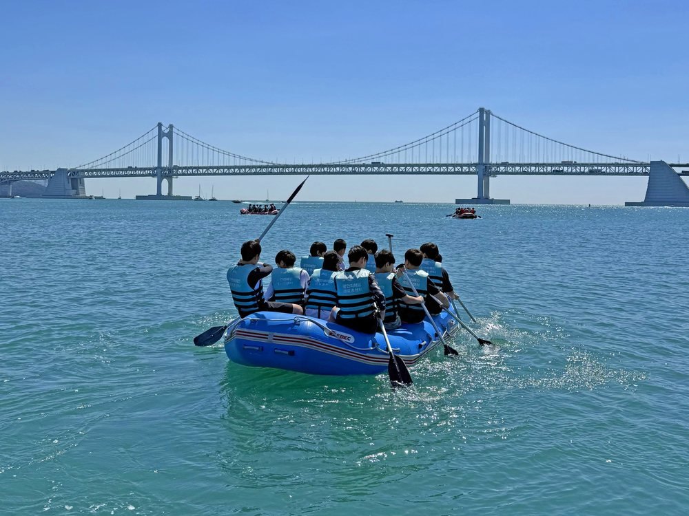 以廣安大橋為背景乘坐漂流艇的人們